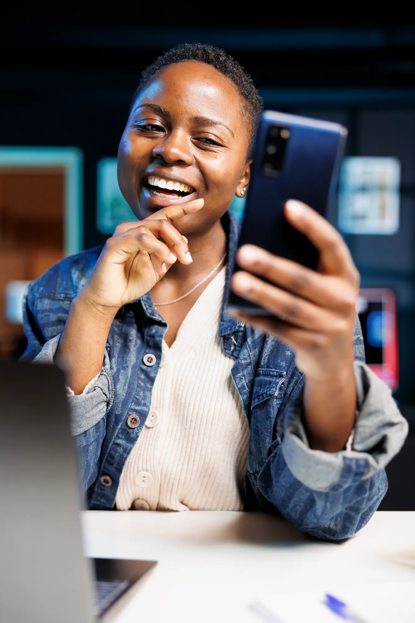 A smiling woman holding up her phone
