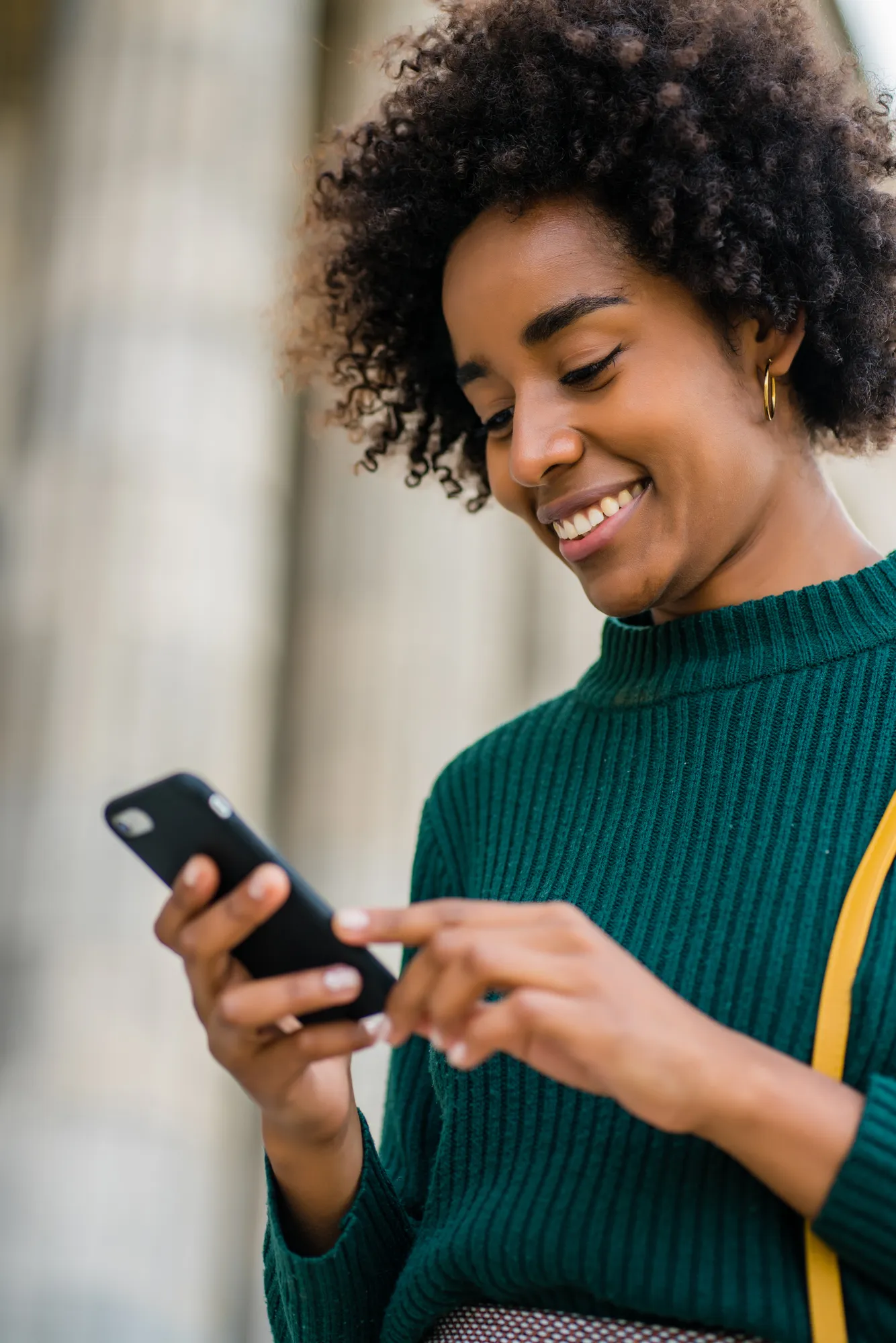 A woman checking her investments on her phone in the city